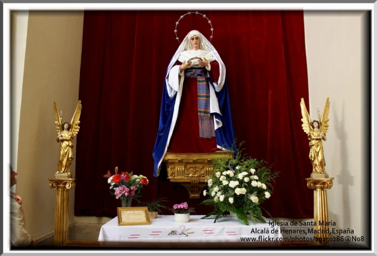 the statue of saint michael of mount cristo is in front of a red curtain