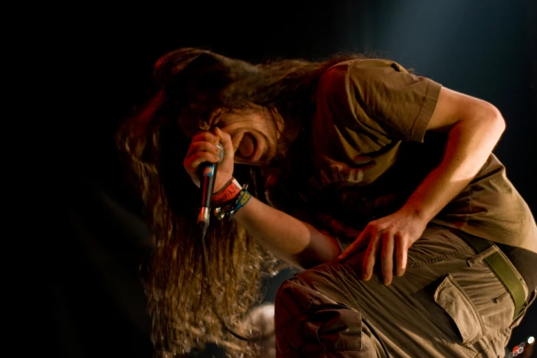 a man with long hair in front of a microphone