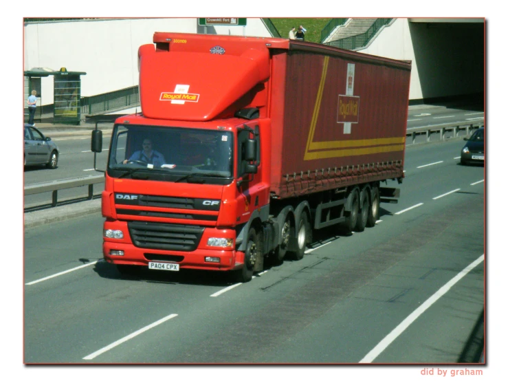 the red semi truck drives down the highway