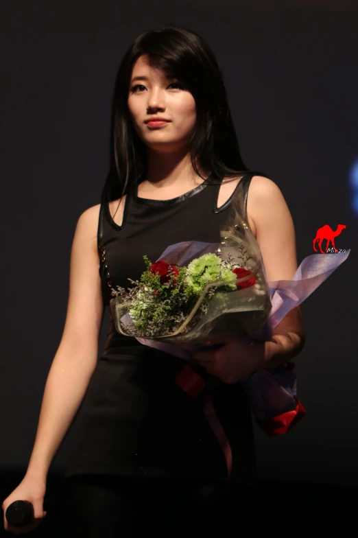 an asian woman is holding a bouquet of flowers