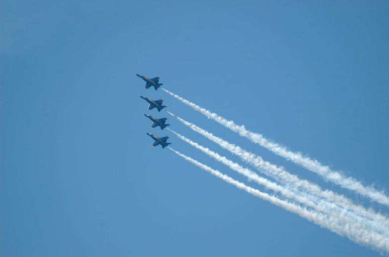 six planes fly close together leaving trails behind them