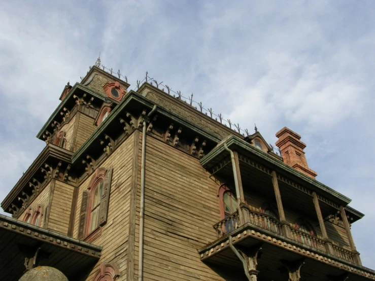 the upper story of a victorian style house with an iron fence and balconies