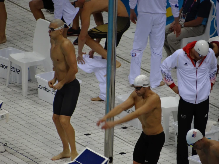 the man without a shirt is swimming in the pool