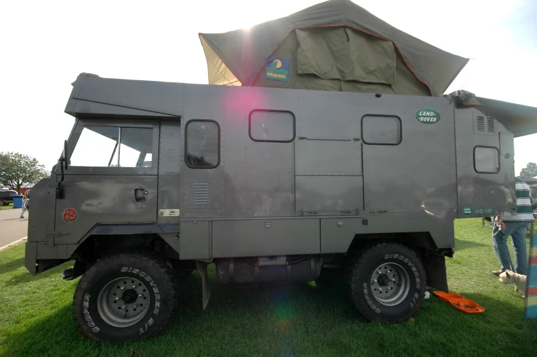 people gather around a large army vehicle on display