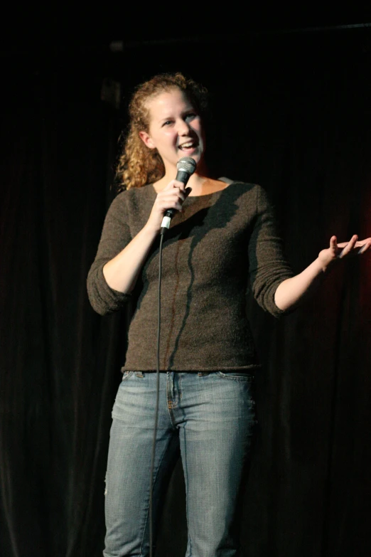 a woman on stage singing and laughing