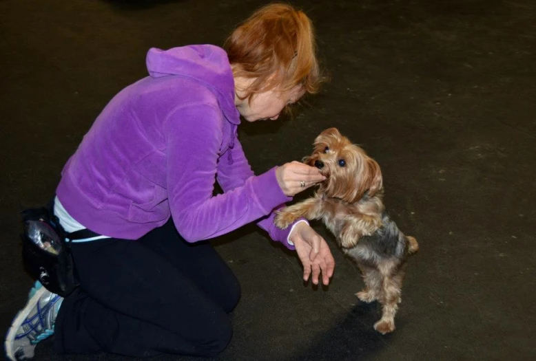 an older woman holding on to a little dog