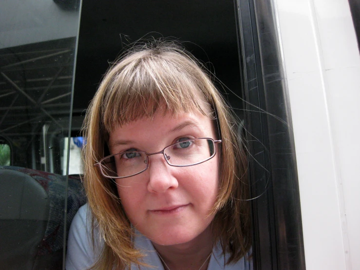 a woman in glasses poses for the camera