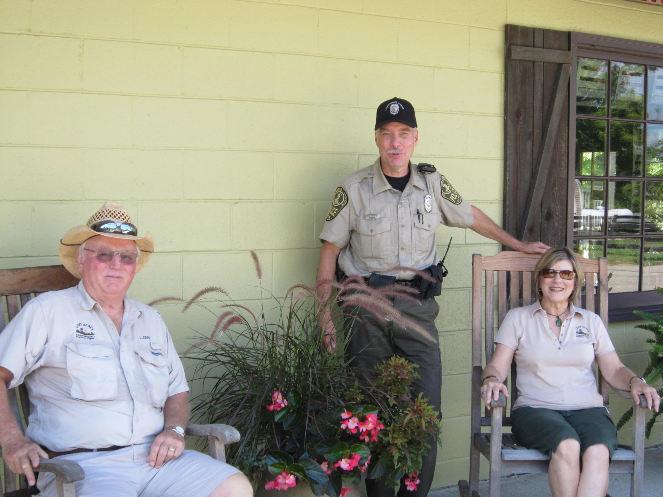 a man standing next to two women sitting down