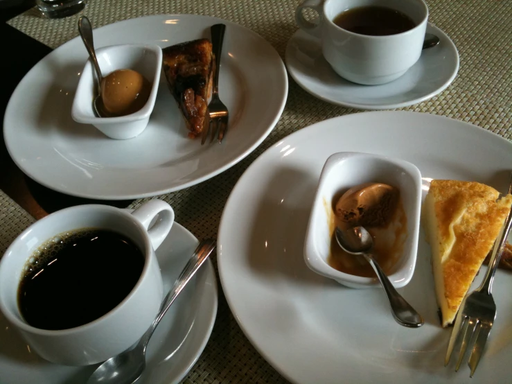 plates on a table with desserts and coffee