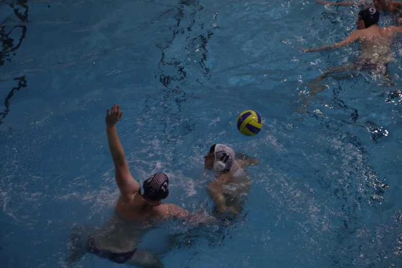 two people playing volleyball in a pool