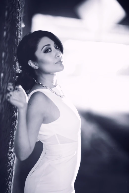 a woman leaning against a wall posing for a pograph