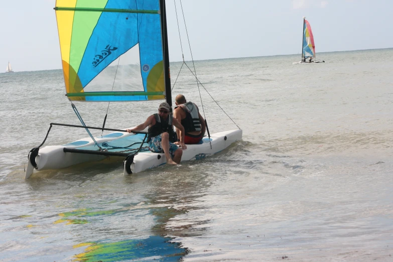 two men riding a catamaran in the water