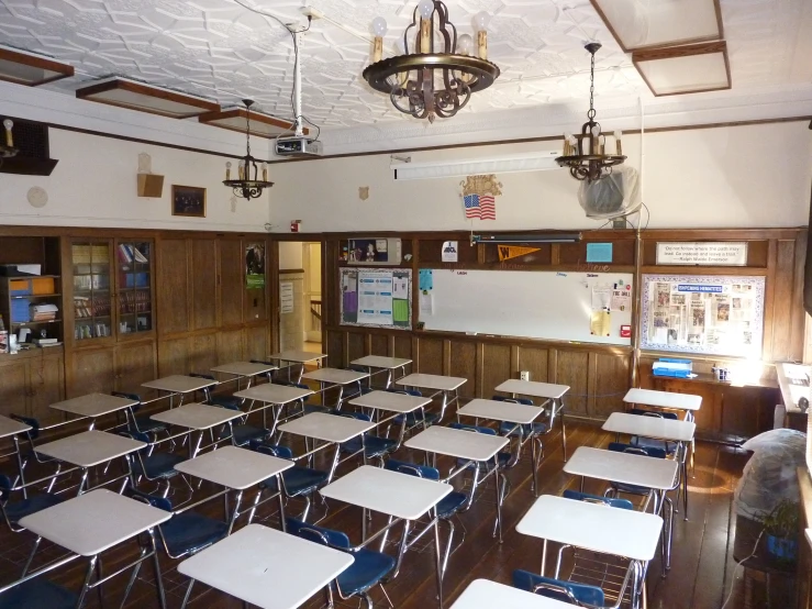 a classroom with many tables and a chandelier