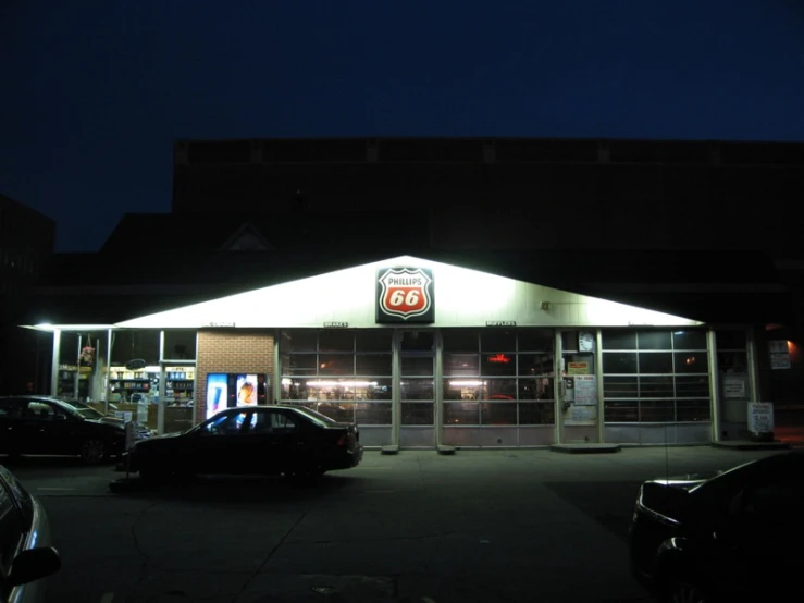 cars sit parked outside of a gas station