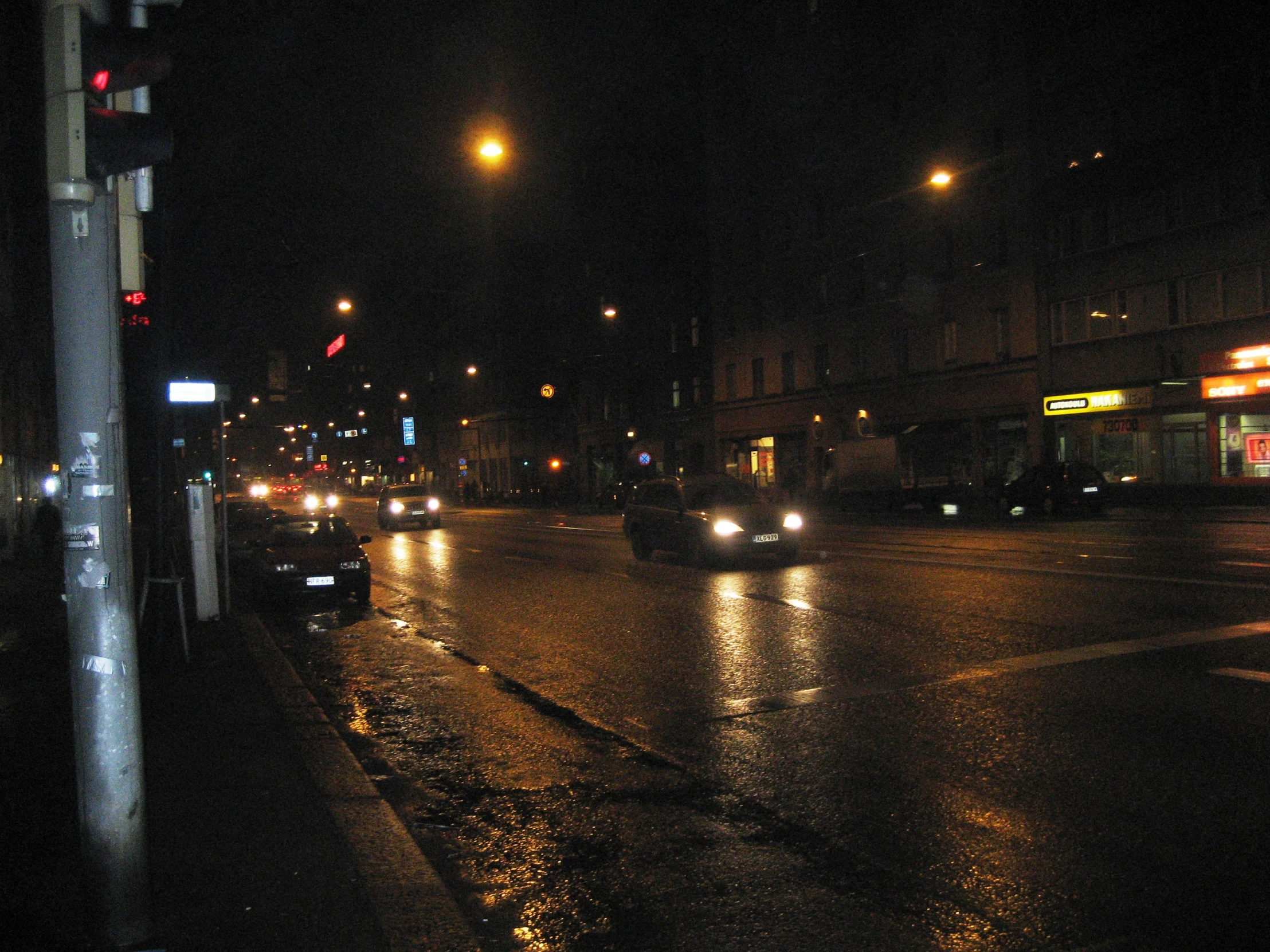 some lights and a building at night on a wet street