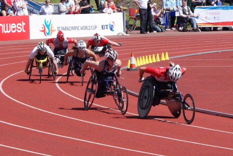 there are several men in wheelchairs racing down a track