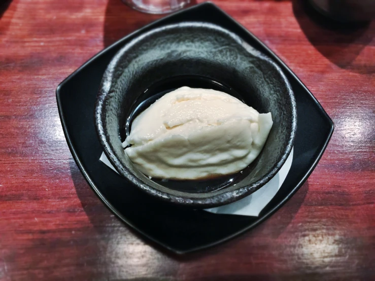 a large white ice cream sits in a black bowl