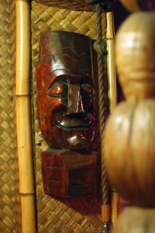 an old, carved mask in a basket on display