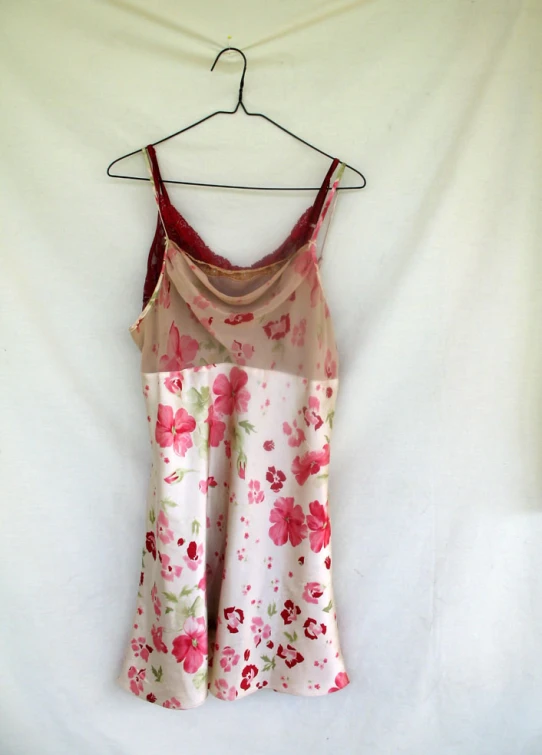 a pink and white top hanging up on a clothes rack