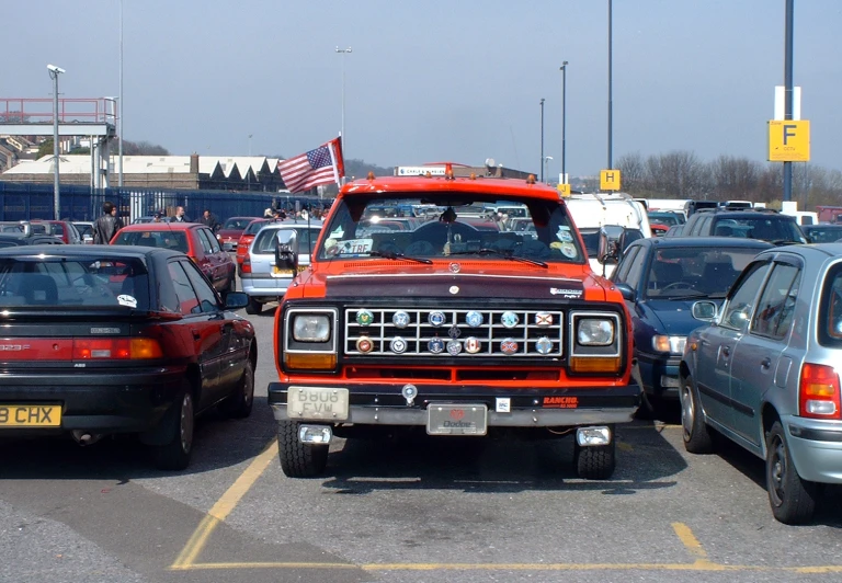 a red truck is in the middle of a parking lot