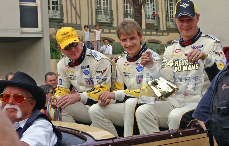 three drivers giving thumbs up while riding in a convertible