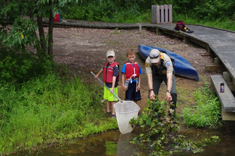 a man holding a net in front of two small boys