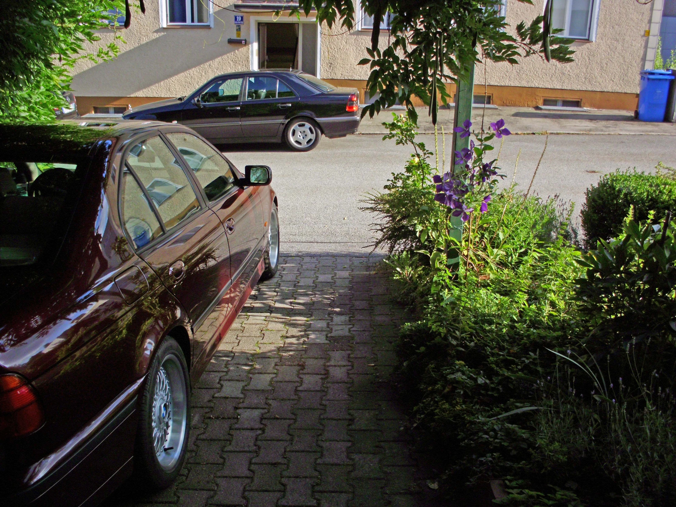 a small red car is parked by the curb