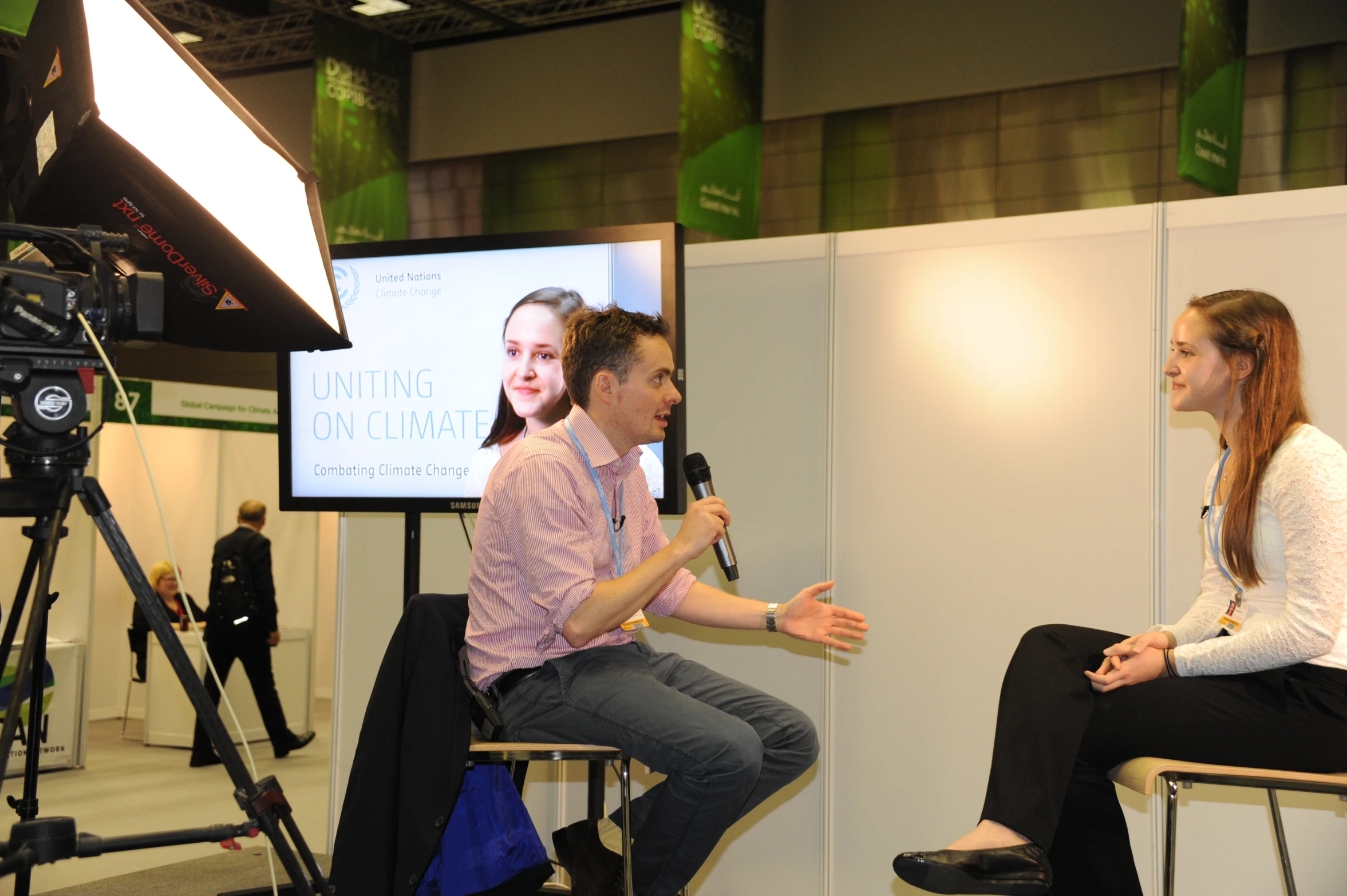 a man and woman sitting on chairs with a microphone