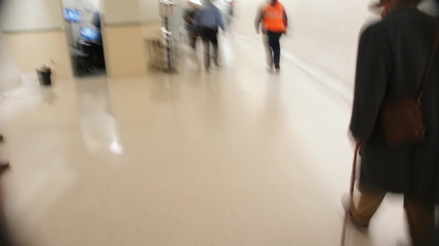 people walk down the hallway of an airport