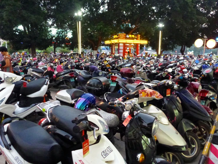 a huge group of motorcycles parked together in a parking lot