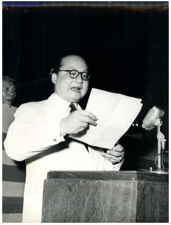 an old picture of a man holding up papers