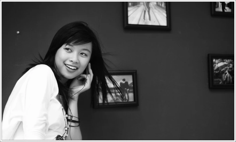 black and white pograph of woman in a white shirt talking on her cellphone