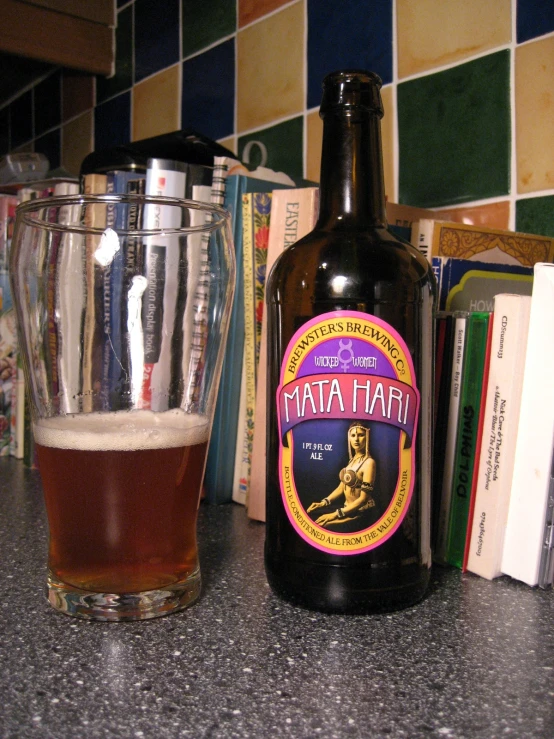 a close up of a bottle of beer near a cup