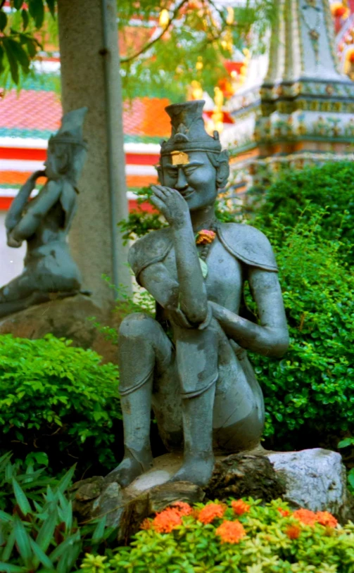 statues of men sit in a green garden