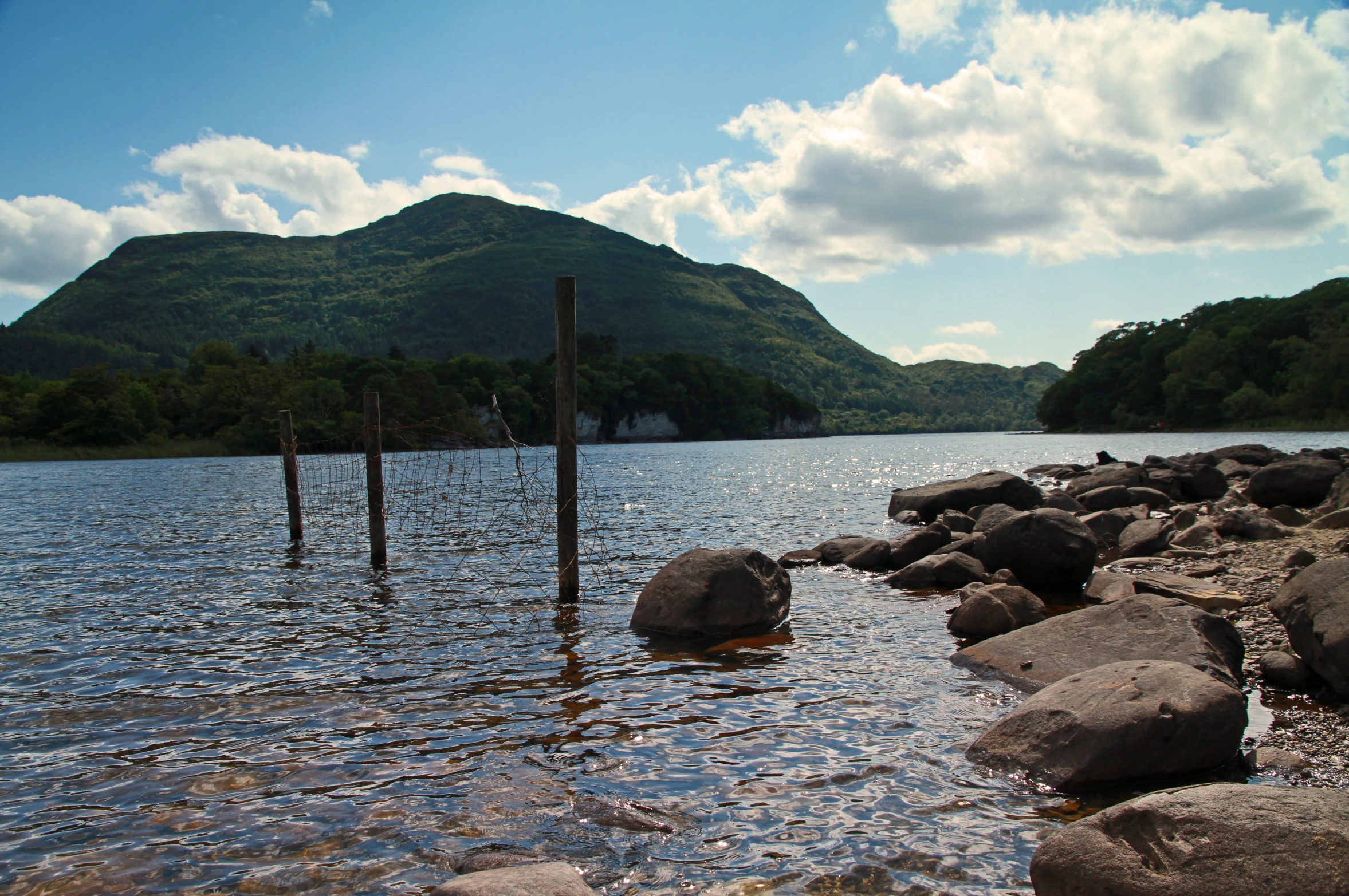 a mountain with some rocks near the water