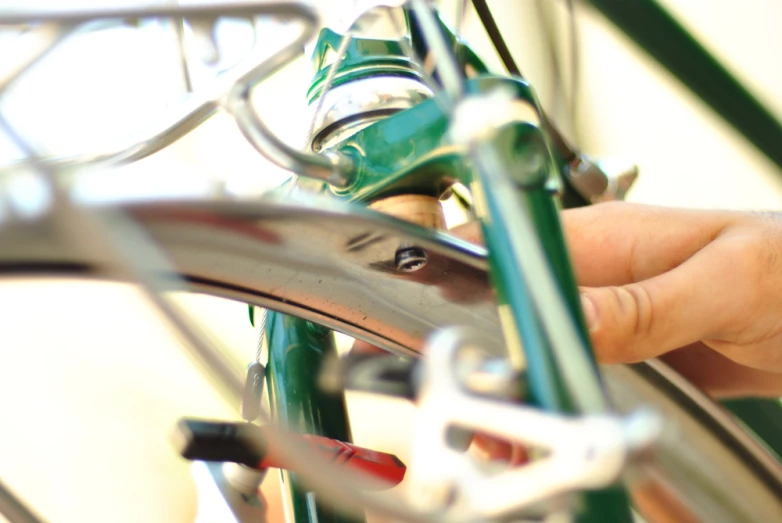 a close up view of a person holding the handlebar of a bicycle