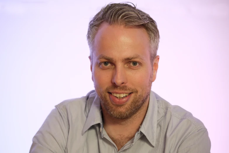 a man in grey shirt posing for a po