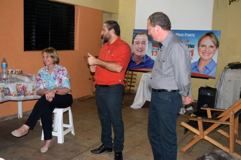 three men and a women are standing in front of two pos