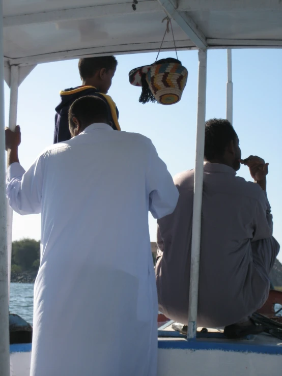 several men sitting on the back of a boat