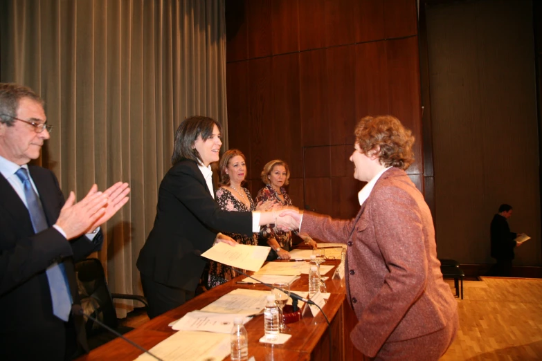 a man and woman shake hands over an agreement