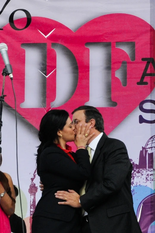 two people kissing while a microphone is seen in the background