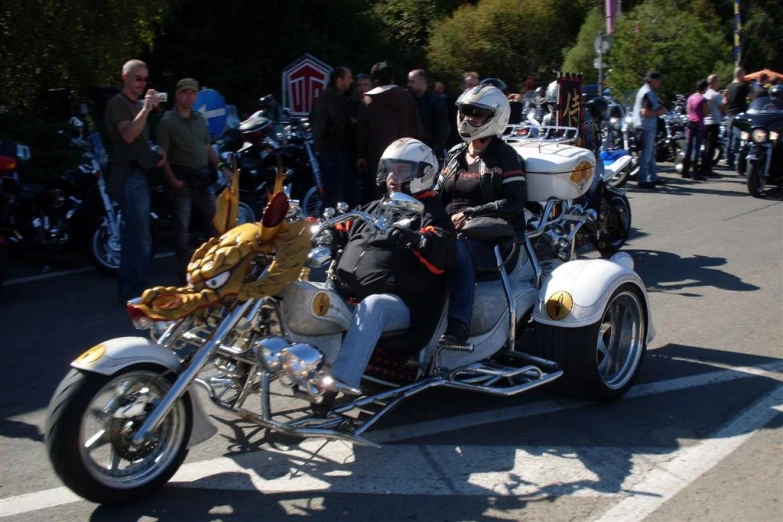 two people in black leather jackets are on a white motorcycle