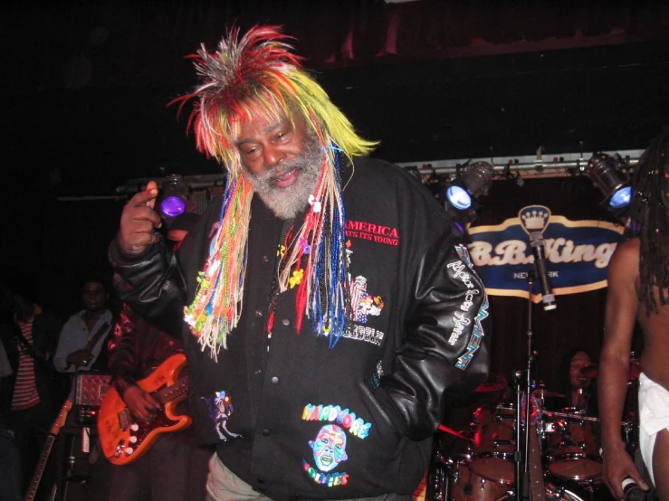 a man with long dreadlocks and beard standing in front of microphone