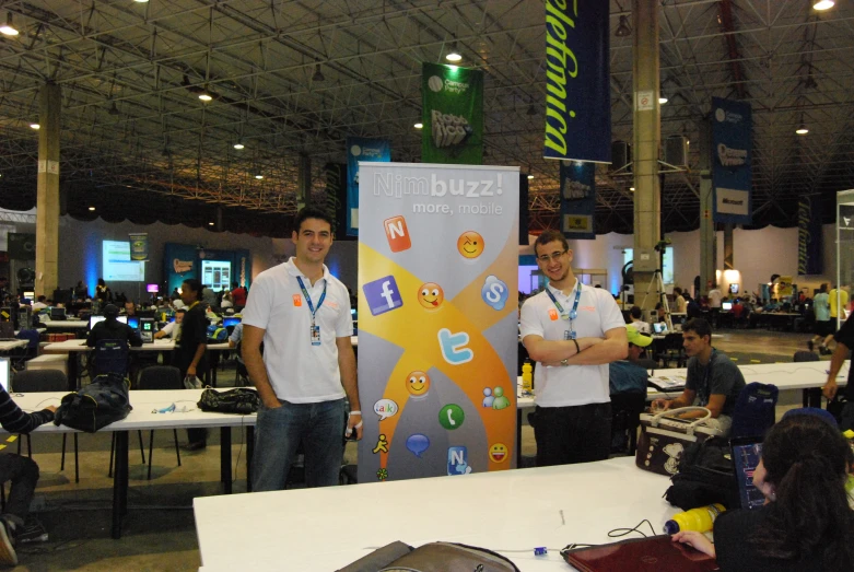 two men standing next to a sign in a room