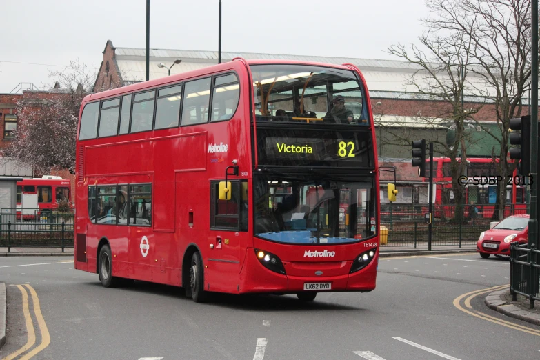 a red double decker bus on a city street