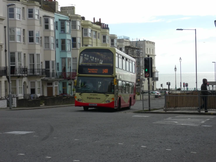 a double decker bus at an intersection with building near by