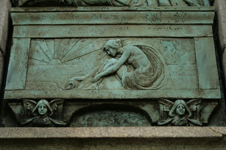 closeup of a green relief with the heads of men sleeping