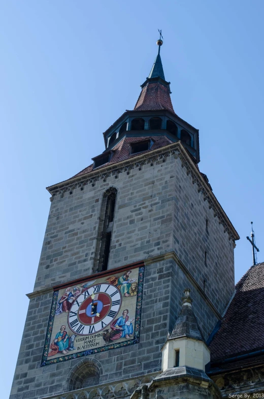 the tall clock tower with an elaborate mosaic mural