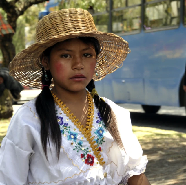 woman with a hat and beads is staring at the camera