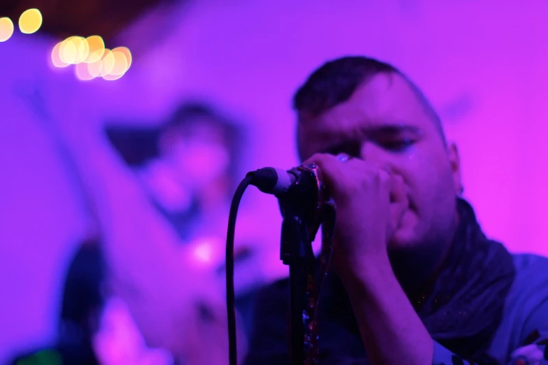 a man playing the guitar and singing into a microphone